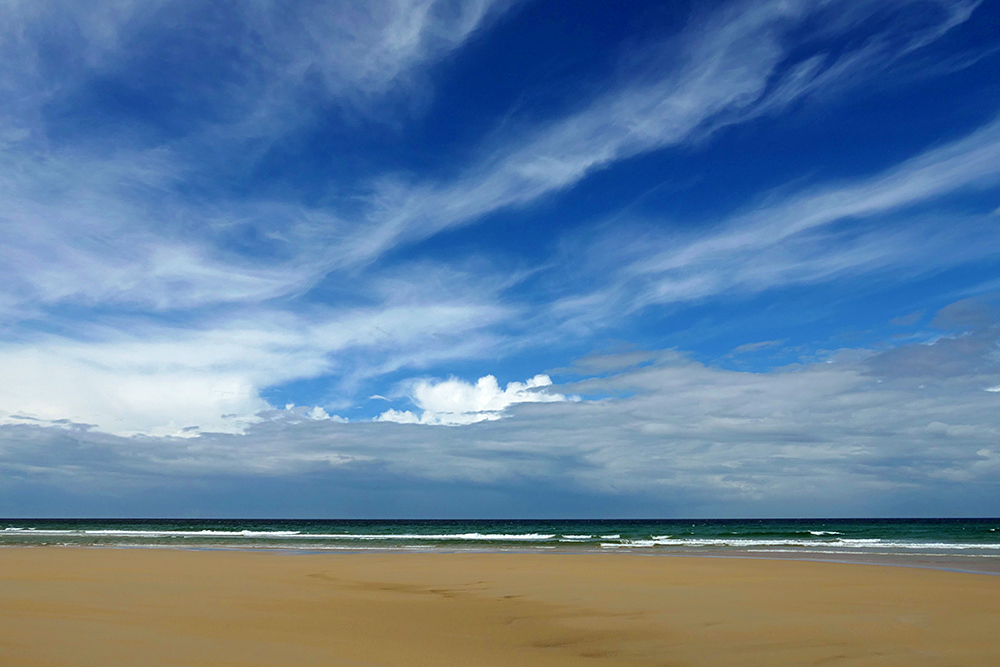 Picture of a variety of clouds over a beach looking out to the Atlantic