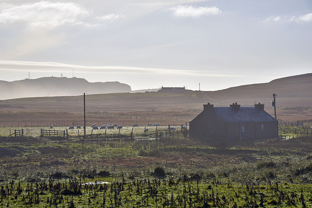 Picture of a view over a rural landscape with two cottages/crofts on a hazy but sunny November day