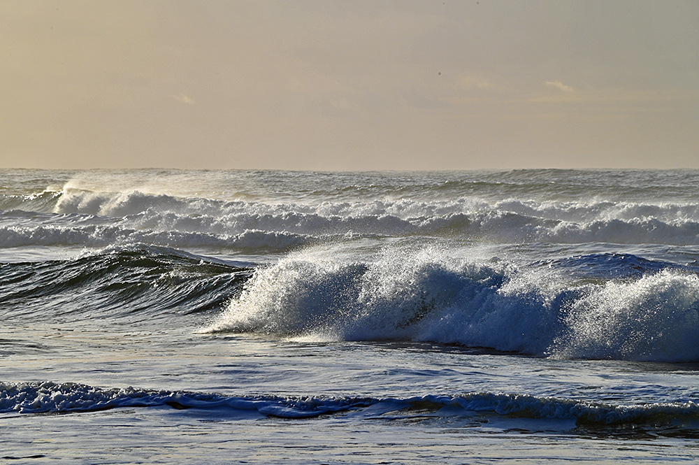 Picture of waves breaking as they approach a beach in some mild afternoon light