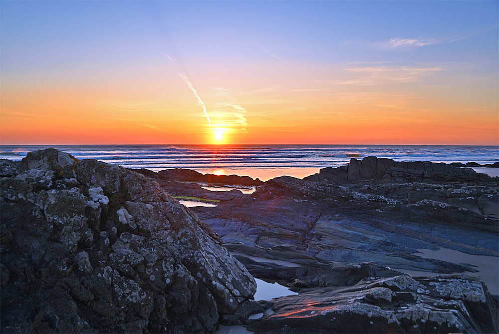 Picture of a sunset over the Atlantic behind some coastal rock
