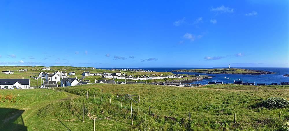 Panoramic picture of a view over two coastal village and a lighthouse on a small offshore island